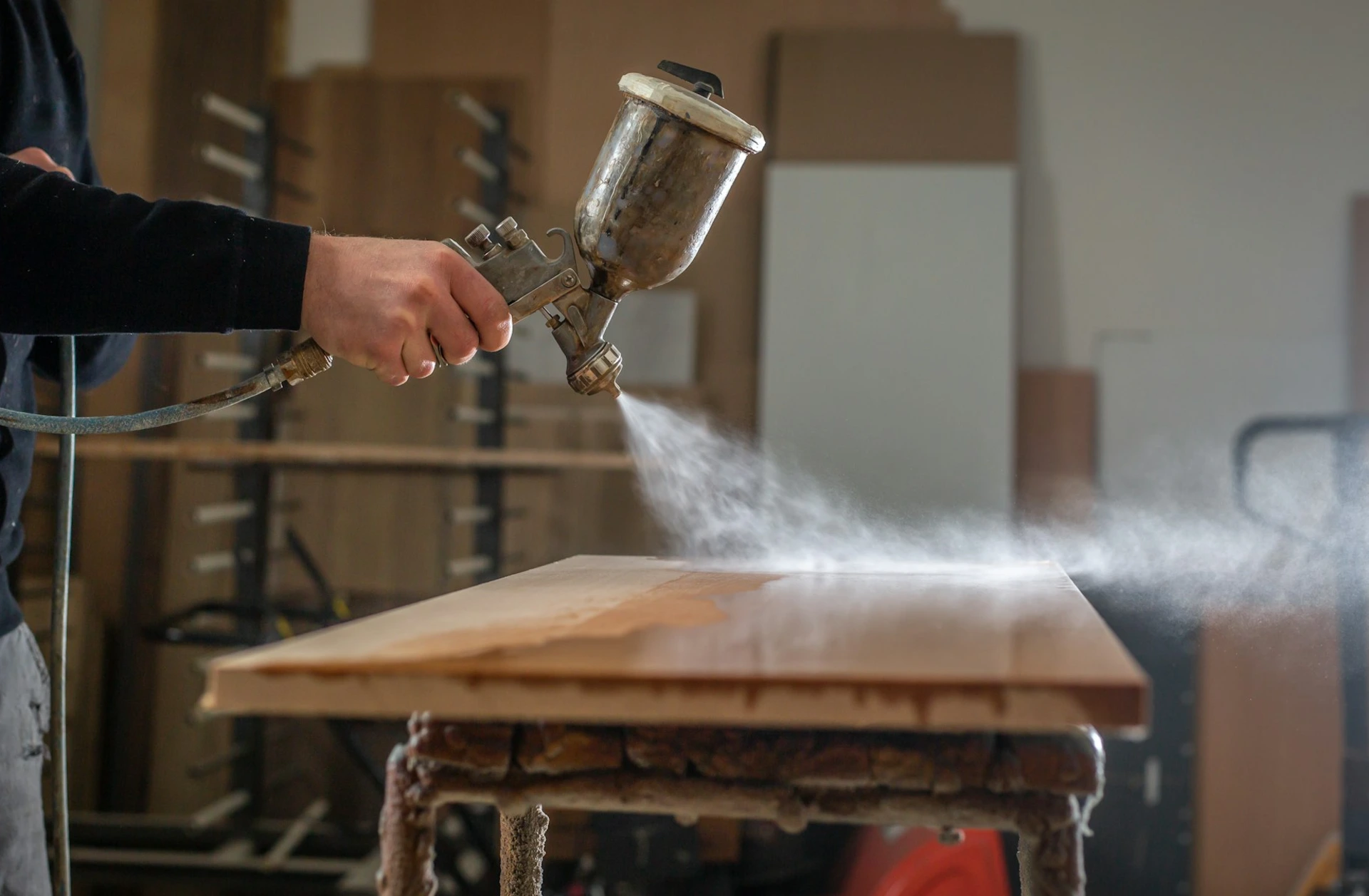 a person using a spray gun for refinishing
