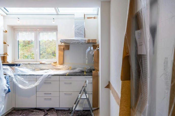 room getting rernovated with white wooden cabinet near window