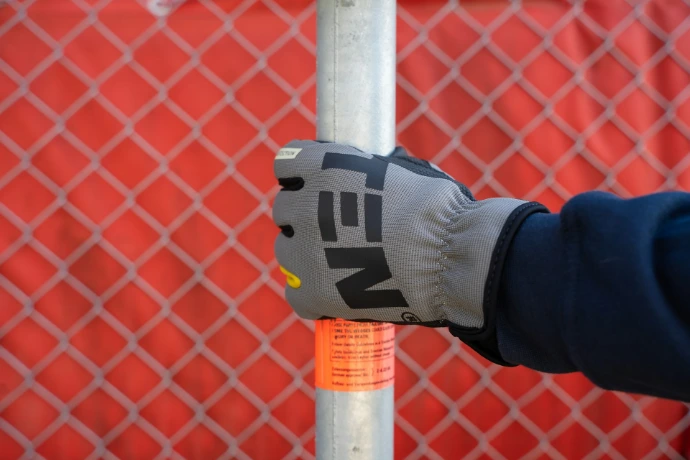 a person wearing a glove is holding a pole