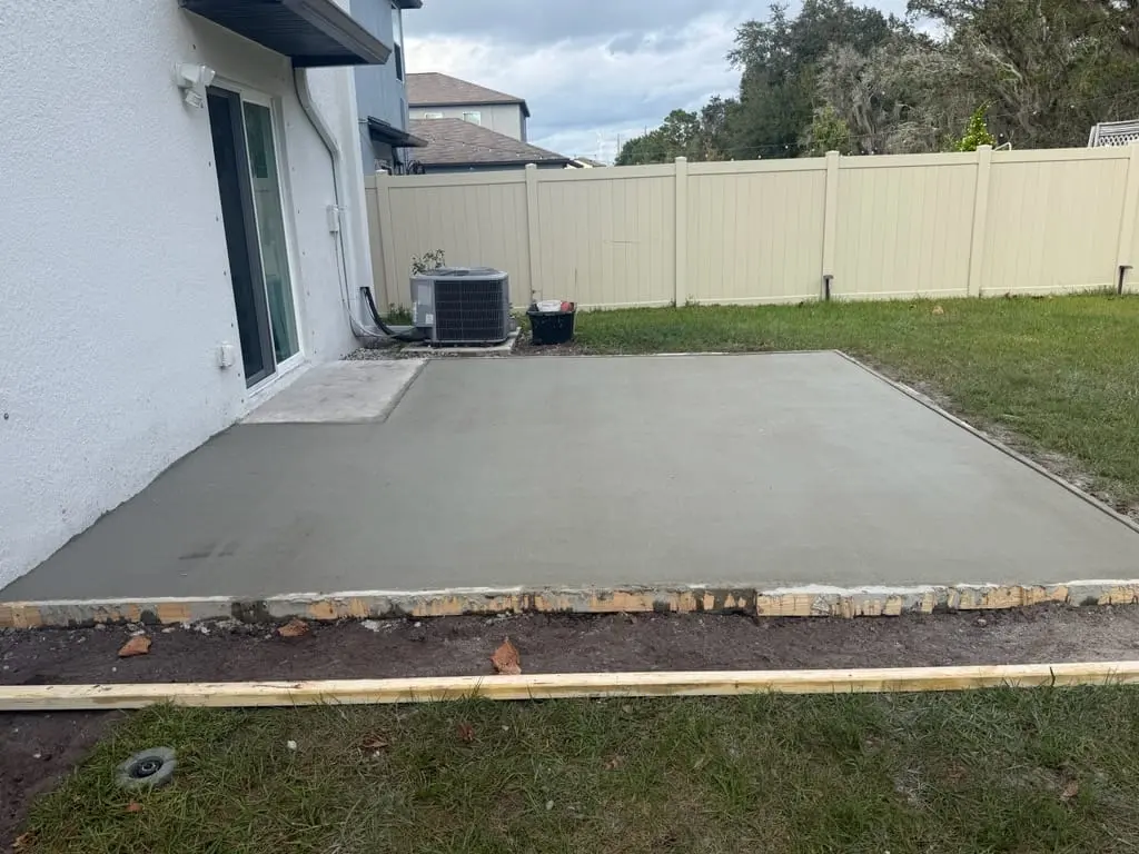 Fresh concrete patio slab installed behind a residential home