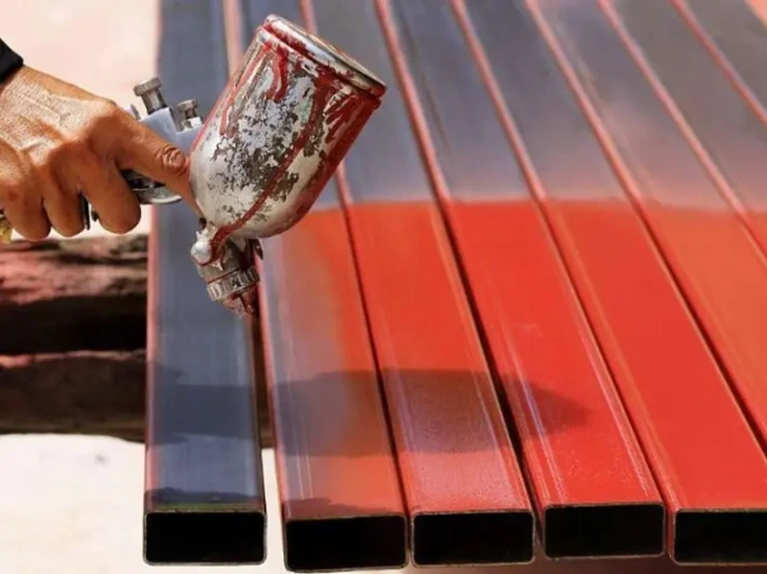 spray gun applying red protective coating