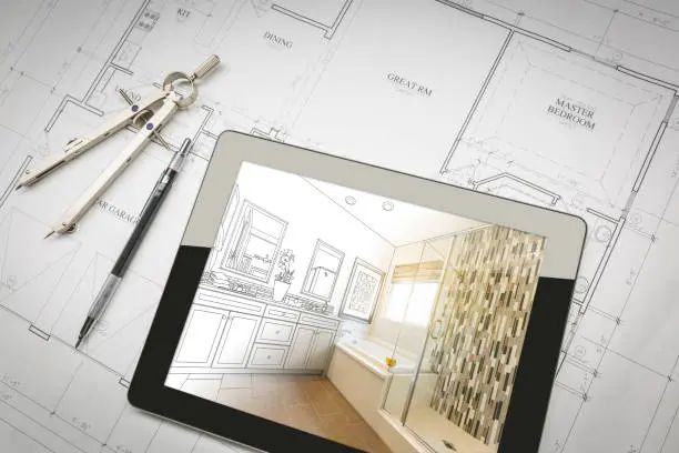 A set of floor plans is spread out on a desk, with drafting tools on top