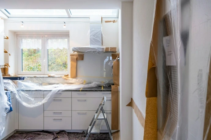 room getting rernovated with white wooden cabinet near window